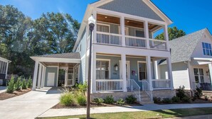 A two-story house with a front porch, a garage, and a well-maintained lawn.