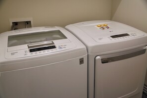 Two white front-loading washing machines with control panels, one with a digital display and the other with a simpler interface. - The Bluebonnet - Stunning Southern Charm Retreat! (Oxford)