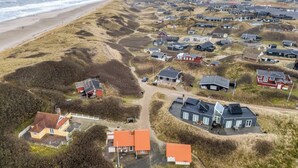 An aerial view of a coastal residential area with houses surrounded by dunes and a beach. - Modernized holiday home, centrally located in one of Søndervig's best locations (Ringkøbing)