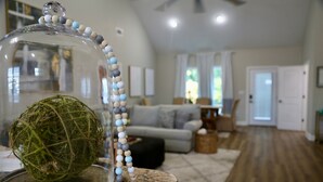 Un salon agrémenté d’un globe en verre servant de pièce maîtresse, d’une guirlande de perles et d’une boule de mousse posée sur une table.