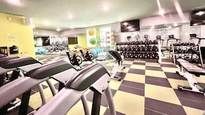 Uma academia com esteiras, bicicletas ergométricas e aparelhos de musculação.