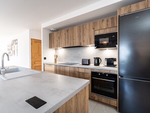 A modern kitchen with a stainless steel refrigerator, a built-in oven, a microwave, and a coffee maker. - New 5-room Apartment 20m from slopes with double garage (La Plagne Montalbert)