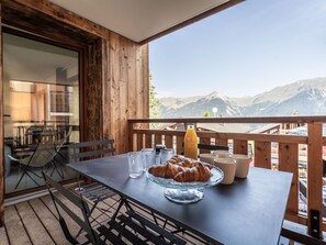 A wooden deck with a table set for breakfast, overlooking a mountainous landscape. - New 5-room Apartment 20m from slopes with double garage (La Plagne Montalbert)
