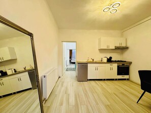 Fridge, coffee/tea maker, cookware/dishes/utensils, dining tables