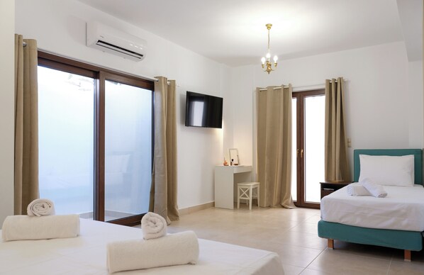 Habitación de hotel con dos camas, televisión, escritorio y una silla.