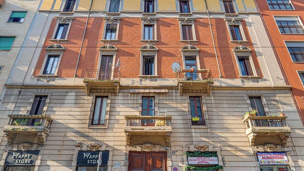 A multi-story building with a row of shops on the ground floor, including a 'Happy Store'.