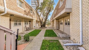 A corridor with a central walkway flanked by two-story buildings with brick facades and windows. - Porcher Villas 3 - Near Ocean! (Myrtle Beach)