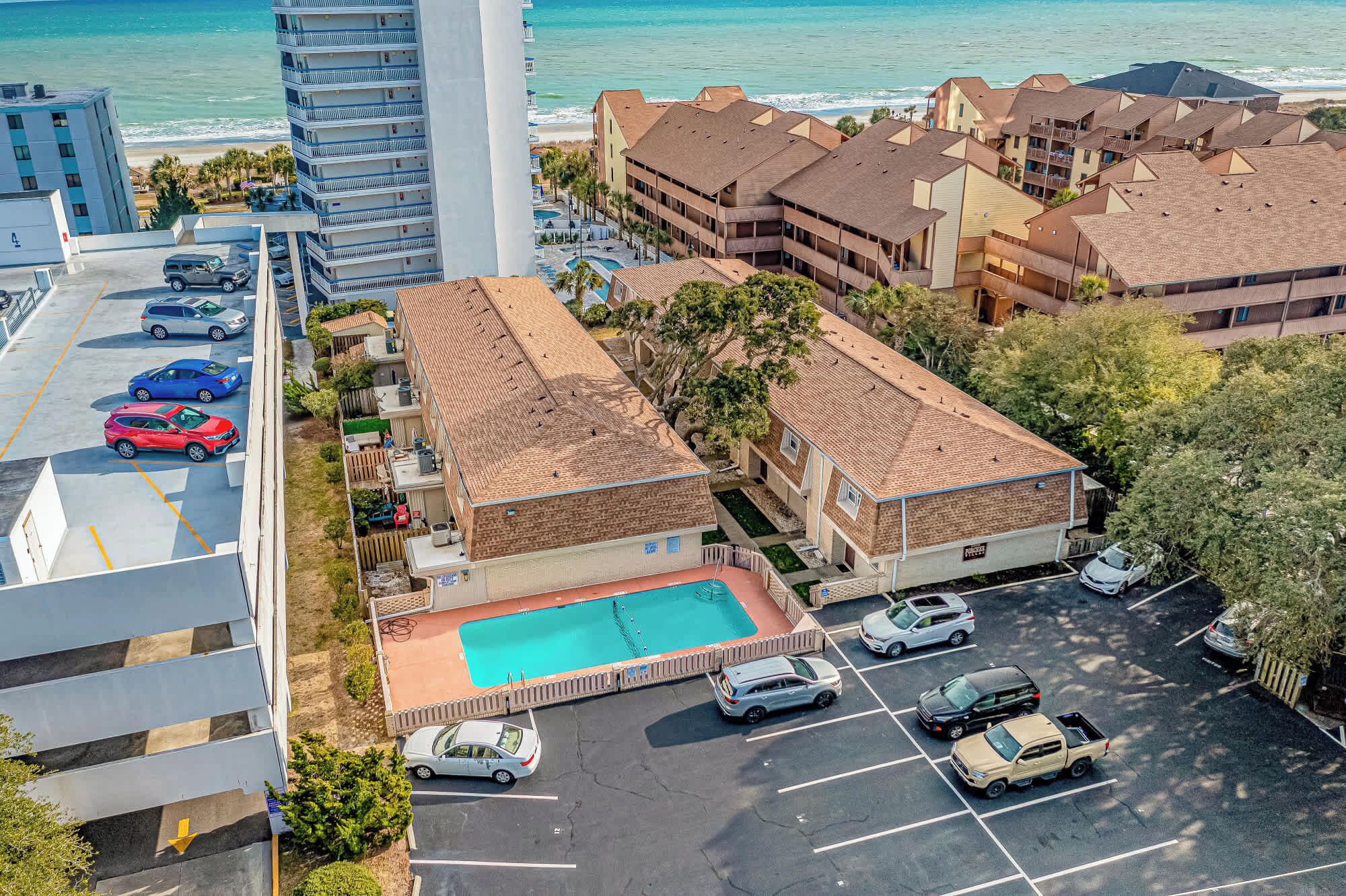 Un hotel con piscina, estacionamiento y vista al océano.
