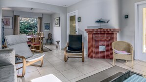 Una sala de estar moderna con chimenea, comedor y vistas al exterior.