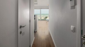 Un couloir menant à un balcon d’où l’on peut admirer la plage.