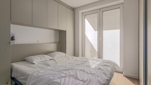 Une chambre à coucher avec un lit, une fenêtre et des rangements intégrés.
