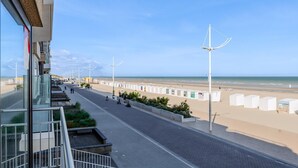 A seaside promenade with a clear view of the beach, street lamps, and a row of beach huts. - 3 bedroom accommodation in Sint Idesbald (Sint Idesbald)