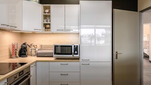 A modern kitchen with white cabinetry, a stainless steel microwave, and a built-in oven. - 3 bedroom accommodation in Sint Idesbald (Sint Idesbald)