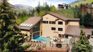 Un grand bâtiment doté d’une piscine, de nombreuses fenêtres et d’une terrasse.