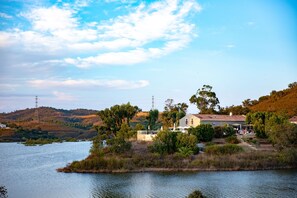 Una propiedad junto al lago con una casa, un muelle y vegetación circundante.