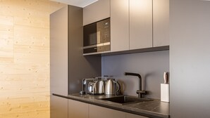 Eine moderne Küche mit integriertem Mikrowellenherd, Toaster und Wasserkocher auf einer stilvollen Arbeitsfläche.