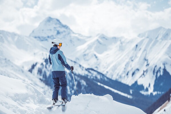 A person in winter gear standing on a snow-covered slope with a mountain in the background. - Apartment in Tyrol Near ski Area (Lermoos)