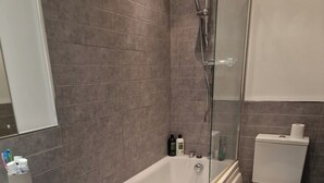 A modern bathroom with a bathtub, toilet, and sink. - Cozy Two Bedroom Chalet in Sidmouth (Sidmouth)