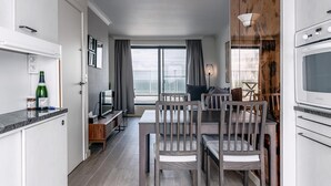 Una cocina moderna con comedor, un ventanal con vistas y una pared de acento de madera.