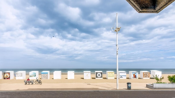 A beach with a row of white planters, a bench, and a bicycle. - 2 bedroom accommodation in Sint-Idesbald (Sint-Idesbald)