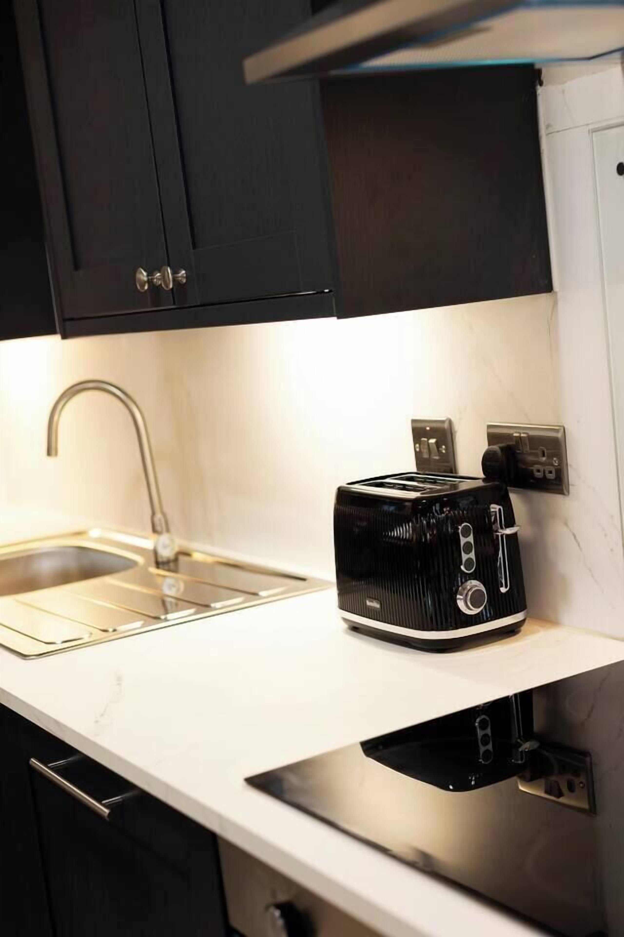 A kitchen with a built-in toaster, a sink, and a countertop.