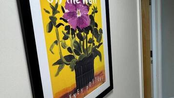 Een lijst met een poster waarop een potplant staat afgebeeld, met de tekst 'Off the Wall' en 'Mock Kney Posters'.