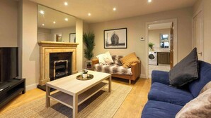 Una sala de estar con chimenea, sofá y televisor.