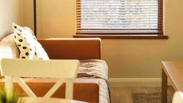 A cozy bedroom with a bed, a desk, and a lamp.