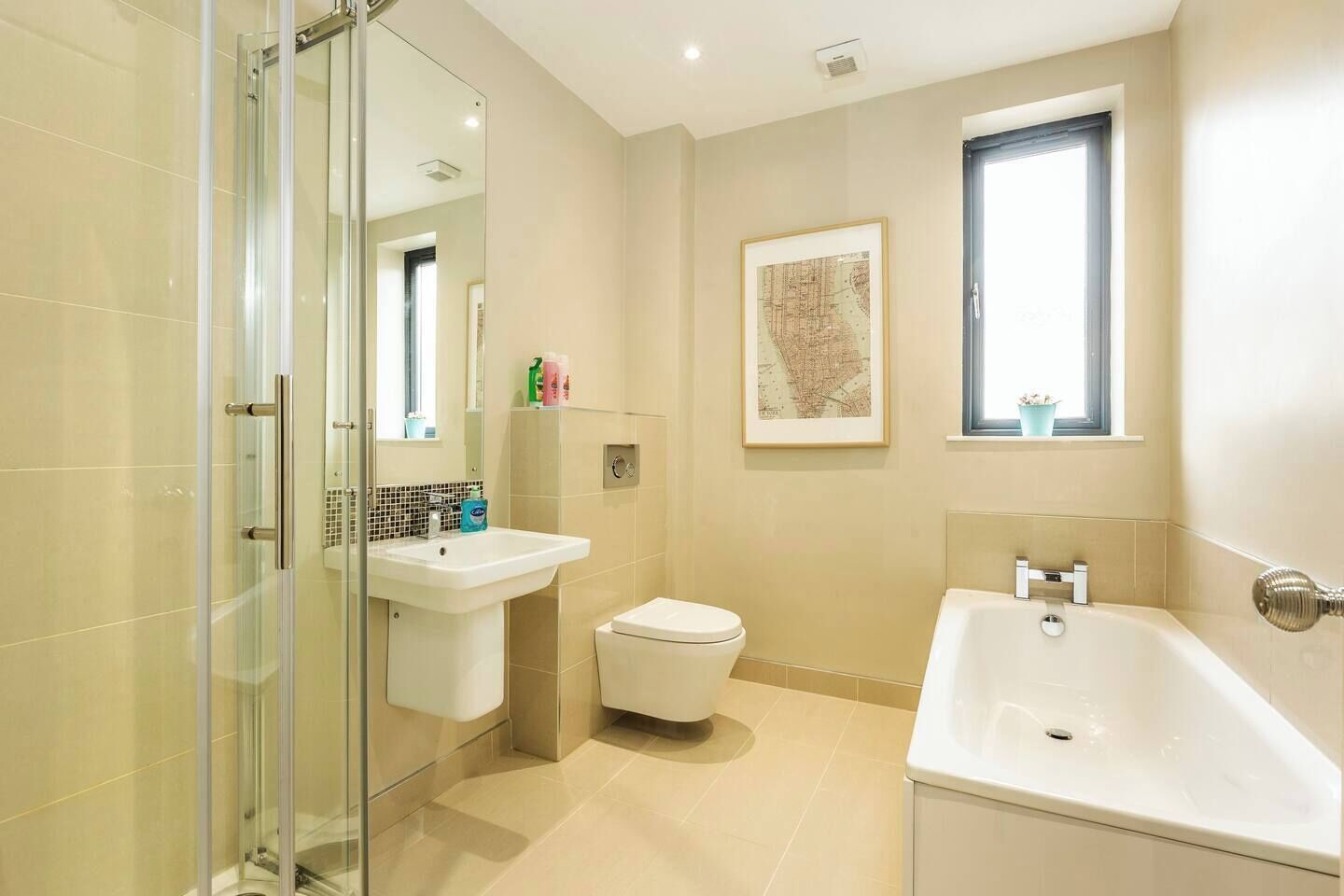A modern bathroom with a glass shower enclosure, a toilet, a sink, and a bathtub.