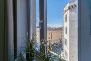 Enjoy the urban view from this room's window, featuring a potted plant and a glimpse of the surrounding cityscape.