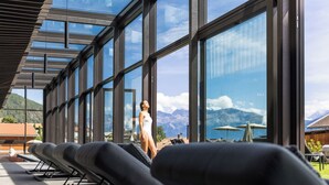 A modern hotel with large windows offering mountain views.
