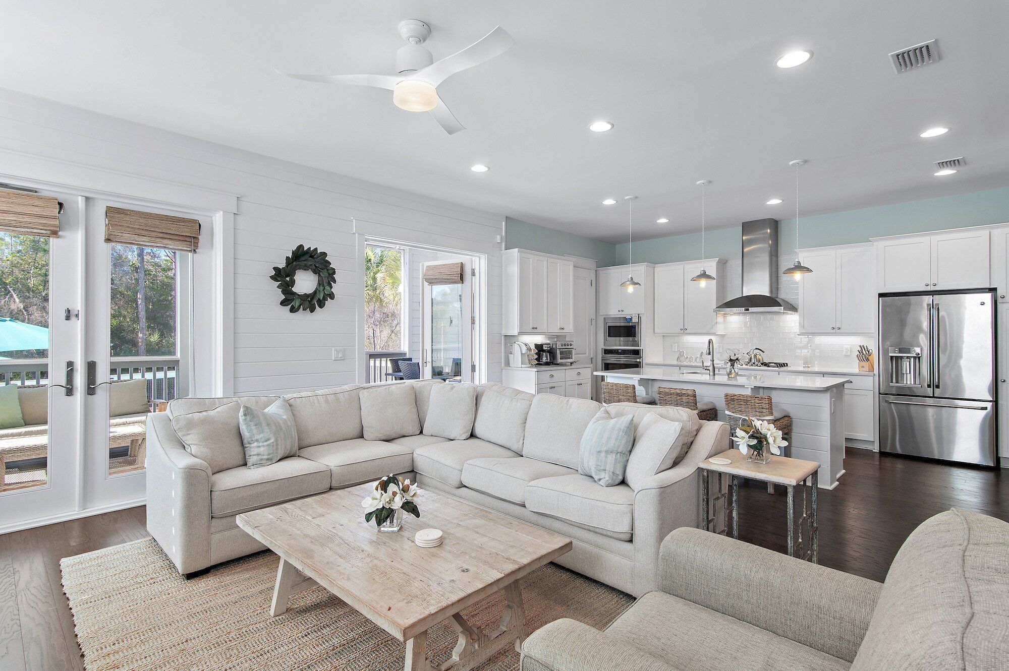 A modern kitchen with white cabinets, stainless steel appliances, and a central island.