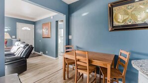 Un comedor con una mesa y sillas de madera, un globo en la pared y una pared azul.