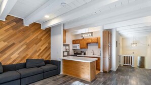 A modern kitchen with wooden cabinets, a central island, and a built-in microwave. - Cozy 3-Bedroom Condo by the Lake & Skiing (Incline Village)
