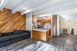 A modern kitchen with wooden cabinets, a central island, and a built-in microwave.
