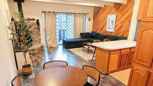 A modern kitchen with wooden cabinets, a dining area with a round table and chairs, a built-in sofa, and a potted plant. - Cozy 3-Bedroom Condo by the Lake & Skiing (Incline Village)
