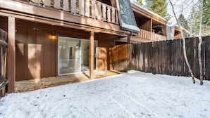 A wooden cabin with a balcony, a covered patio, and a snow-covered ground. - Cozy 3-Bedroom Condo by the Lake & Skiing (Incline Village)