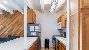 A compact kitchen with wooden cabinets, a refrigerator, a microwave, and a sink. - Cozy 3-Bedroom Condo by the Lake & Skiing (Incline Village)