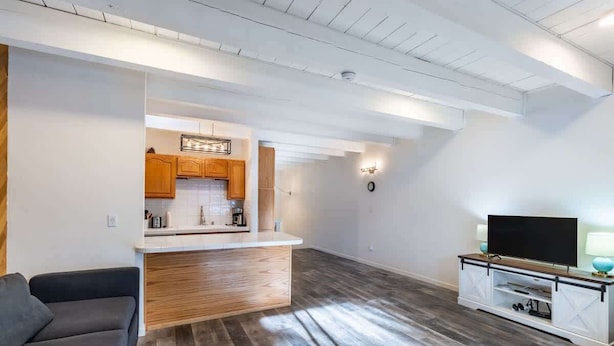 A modern living room with a grey sofa, a wooden coffee table, and a TV stand with a flat-screen TV. - Cozy 3-Bedroom Condo by the Lake & Skiing (Incline Village)