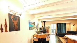 A cozy living area with a fireplace, a dining table with chairs, and a sofa. - Cozy 3-Bedroom Condo by the Lake & Skiing (Incline Village)