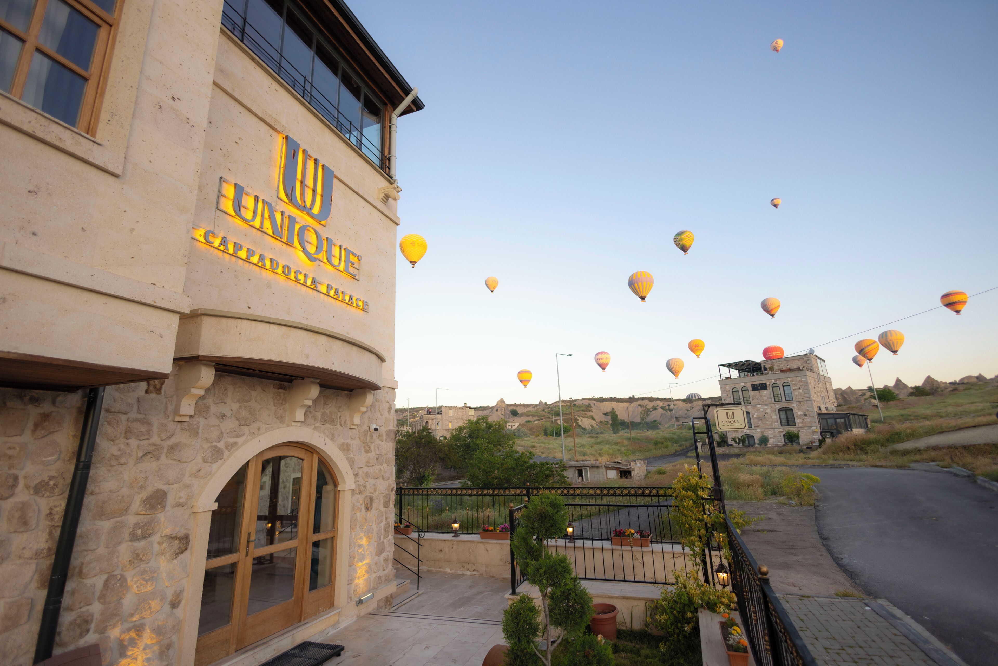 A building with a stone facade and a sign that reads 'UNIQUE CAPPADOCIA PALACE.'