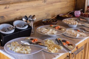 A buffet with various dishes and utensils. - Unique Cappadocia Palace (Nevsehir)