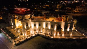 A historic building with a courtyard, multiple balconies, and illuminated windows. - Unique Cappadocia Palace (Nevsehir)