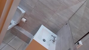 Et badeværelse med et hvidt badekar, toilet og håndvask.