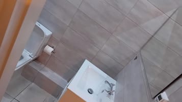 A bathroom with a white bathtub, a toilet, and a sink.