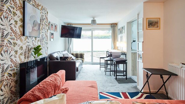A hotel room with a sofa, a TV, a dining area, and a view of the outdoors. - Host Stay Shaftsbury (Nottingham)
