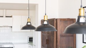 A kitchen with pendant lights, a wooden cabinet, and a potted plant. - Host Stay Exchange Street Living (Liverpool)