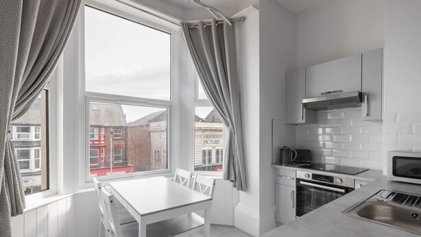 A modern kitchen with white cabinetry, a built-in oven, and a microwave. - Host Stay Aberdeen Walk Apartment (Scarborough)