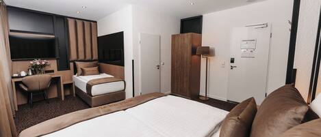 Una habitación de hotel moderna con una cama grande, un escritorio y un armario.