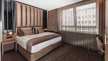 Luxe beddengoed, een kluis op de kamer, een bureau, een laptopwerkplek
